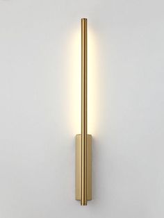 a wall mounted light that is on the side of a white wall and has a gold finish