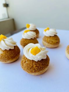 small desserts are arranged on a white table top with frosting and icing