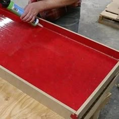 a man working on a red piece of furniture