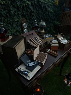 a table topped with lots of books on top of a lush green field