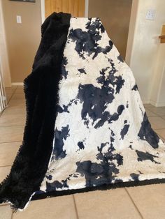 a black and white blanket sitting on top of a tiled floor