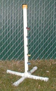 a white fire hydrant sitting in the grass next to a fence