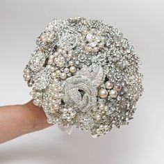 a bridal bouquet is being held by someone's hand on a white background