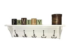 a white shelf with three hooks and two letters that spell out the word family on it