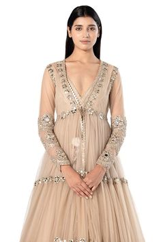 Beige long tiered jacket with mirror embroidery. Comes with sleeveless anarkali with mirror embroidered hem.
Components: 2
Pattern: Embroidered
Type Of Work: Mirror
Neckline: Plunged V
Sleeve Type: Jacket: Long, Anarkali: Sleeveless
Fabric: Anarkali- Organza, Jacket- Net
Color: Beige
Other Details: 
Back tassel tie anarkali
Front tie-up jacket
Occasion: Destination Wedding - Aza Fashions Long Sleeve Lehenga With Gota Work For Eid, Transitional Bandhgala With Gota Work And Long Sleeves, Long Sleeve Gota Work Choli For Eid, Long Sleeve Choli With Gota Work For Eid, Long Sleeve Choli With Sheer Dupatta For Navratri, Anarkali Bandhgala With Gota Work For Festive Season, Transitional Long Sleeve Bandhgala With Gota Work, Anarkali Long Sleeve Choli With Cutdana, Long Sleeve Anarkali Set For Reception And Festivals