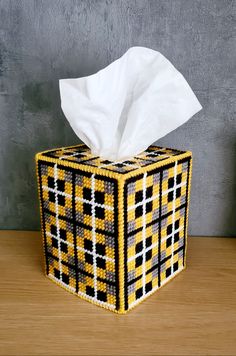 a tissue dispenser sitting on top of a wooden table