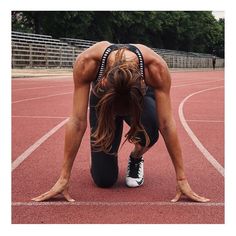 a woman is doing push ups on a track