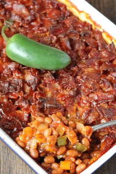 baked beans with a pickle in a casserole dish