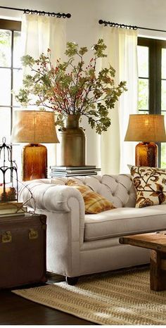 a living room filled with lots of furniture next to two lamps and a coffee table