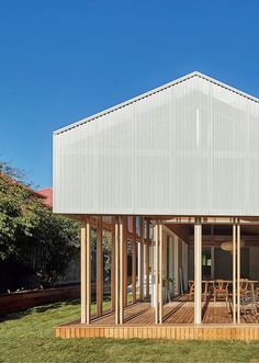 a white house with wooden decking in the grass