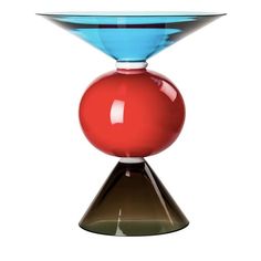 a red and blue vase sitting on top of a table