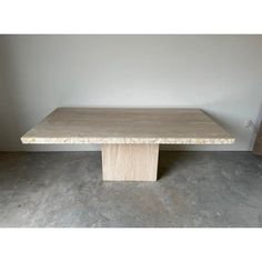 a table that is sitting in the middle of a room with concrete floors and walls