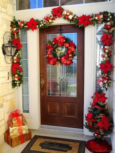 the front door is decorated for christmas with red and silver ornaments on it's pillars