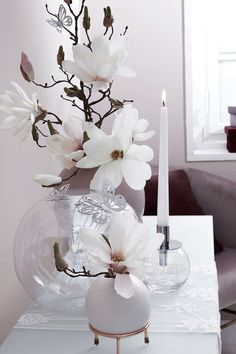 a vase with flowers and a candle on a table