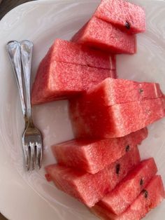 slices of watermelon on a plate with a fork