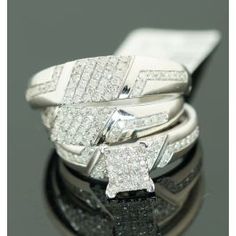 three diamond rings sitting on top of each other in front of a black surface with reflections