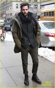 a man in winter clothes standing on the sidewalk