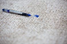 a blue pen laying on the floor next to it's end