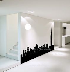 an empty room with a large city skyline wall decal on the wall and stairs leading up to it