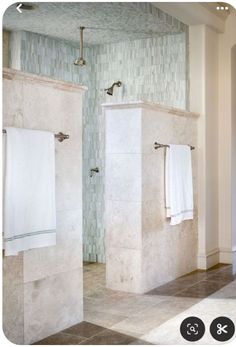 a bathroom with two white towels hanging on the wall and one in the shower stall