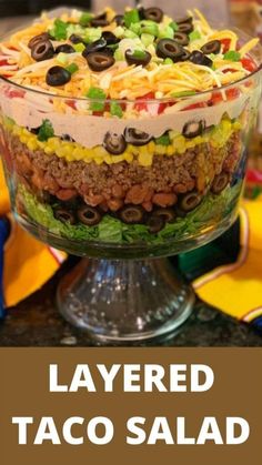 layered taco salad in a glass dish with the title layered taco salad