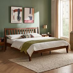 a bed room with a neatly made bed and two pictures on the wall above it