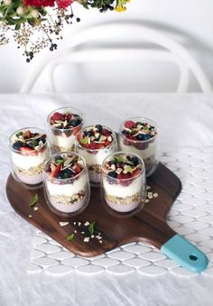 small desserts are arranged on a wooden tray