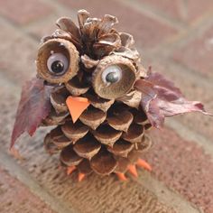 an owl made out of pine cones sitting on the ground