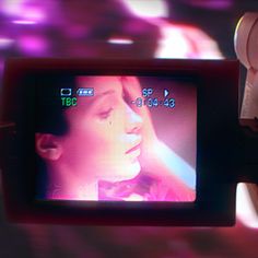 a close up of a video camera with a woman's face on the screen