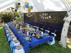 there is a table set up for a party with blue and white tablescloths