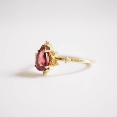 A beautiful garnet set in 14K solid gold. The gorgeous ring for an understated classy look. Handcrafted in your choice of 14K Yellow gold, Rose gold and white gold. A classy piece to treasure for time to come. Materials: - 14K solid gold - 7x5mm natural pear-shaped garnet stone - Round CZs (what's this?) ** This item is specially made for you. Please allow 1-2 week lead time. Shipping: Domestic: Free standard shipping within the U.S. International: Free standard shipping for orders over $150 Cus Elegant Pear-shaped Yellow Gold Birthstone Ring, Timeless Pear-shaped Ring For Gift, Timeless Pear-shaped Rings For Gifts, Elegant Yellow Gold Pear-shaped Birthstone Ring, Fine Jewelry 14k Gold Pear-shaped Ruby Ring, 14k Gold Pear-shaped Ruby Ring, Garnet Gem, Garnet Stone, Ring Photos