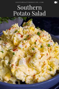 a blue bowl filled with potato salad on top of a table