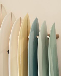 five surfboards are lined up in a row on the wall next to each other