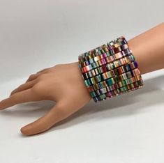 a woman's hand wearing a multicolored bracelet