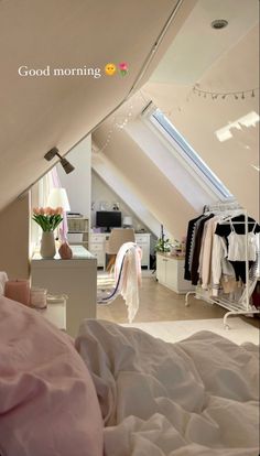 an attic bedroom with white furniture and pink bedding