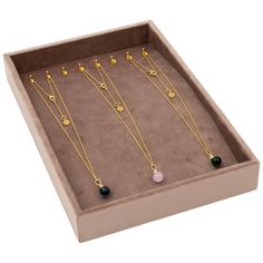 six necklaces in a box on a white background