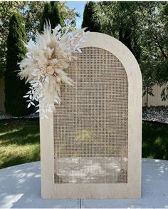 a wooden frame with some white flowers on it and grass in the backgroung