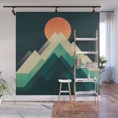 a wall mural with mountains and the sun rising over them in green, orange and yellow colors