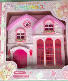 a pink and white doll house in a box