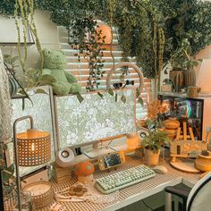 a desk with a computer and plants on it