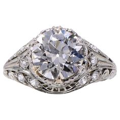 an antique style diamond ring with filigrees on the shoulders and sides, set in