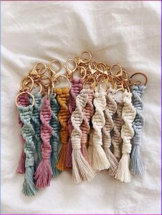 several different colored tassels hanging from a gold chain on top of a white sheet