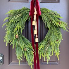 a wreath with bells hanging on the front door