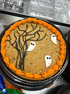 there is a cake decorated to look like a tree with ghost faces and sprinkles