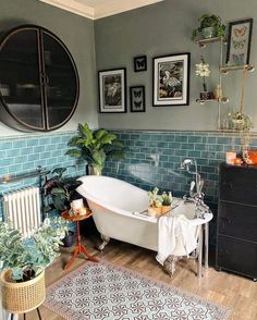 a bath tub sitting next to a white sink in a bathroom on top of a hard wood floor