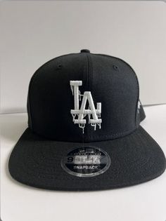 "Drip \"LA\" logo with White thread -New Era 9Fifty adjustable Snapback -color: Black" Affordable Customizable Black Snapback Hat, Black Baseball Cap With Logo For Streetwear, Black Logo Print Baseball Cap For Streetwear, Black Snapback Hat With Flat Crown For Streetwear, Black Fitted Hat With Letter Print For Streetwear, Black Thread, Trucker Cap, New Era, Caps Hats