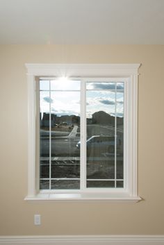 an empty room with two windows and no curtains on the window sill in front of it