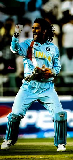 a man with dreadlocks is holding his arms in the air and wearing a cricket uniform