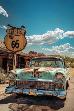 an old rusty car parked in front of a road sign with the number 66 on it