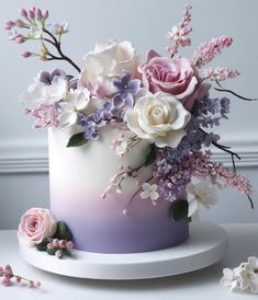 there is a white and purple cake with flowers on it